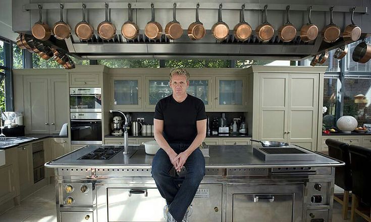 Gordon Ramsay sitter i ett lyxigt restaurangkök med kopparkastruller.